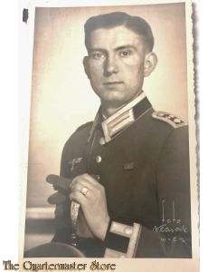 Studio portret german soldier sitting with sword WW2